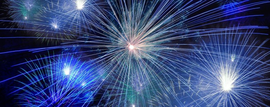 Bright blue fireworks exploding in the night sky.