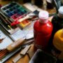 Art supplies including paint bottles, brushes, and a watercolor palette.