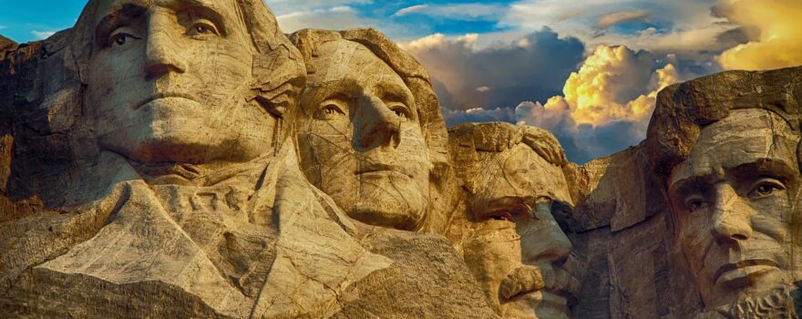 Mount Rushmore National Memorial with four presidential faces against a dramatic sky.